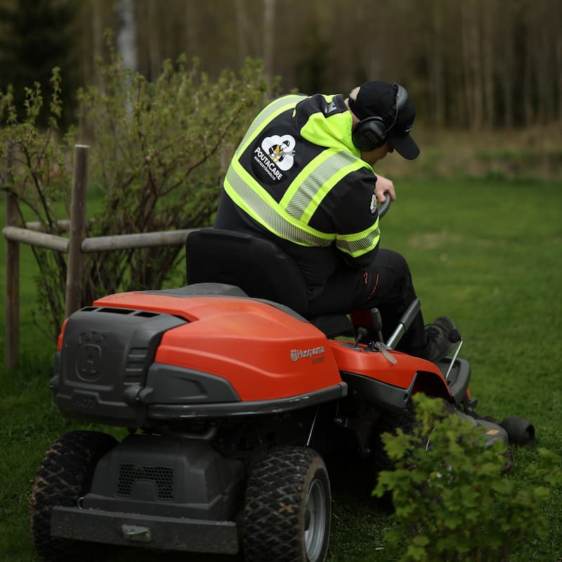 Työmies leikkaamassa ruohoa